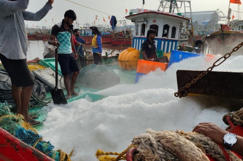 A busy harbor with boats, people, and fishing equipment. 1