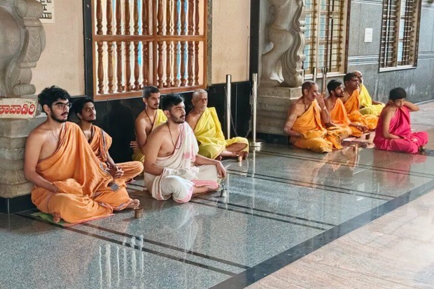 Monks sitting in a temple courtyard. 2