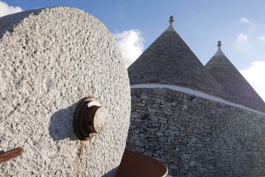 A stone structure with a clock and a conical roof. 5