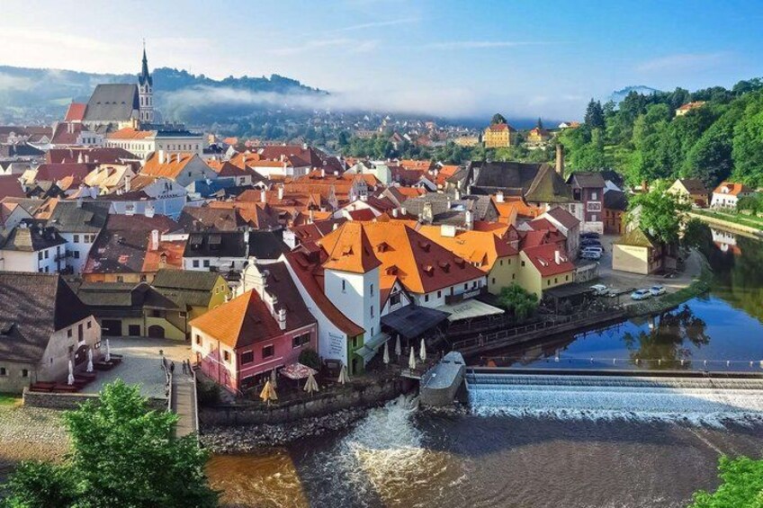 A town with a river, historic buildings, and a prominent church. 4
