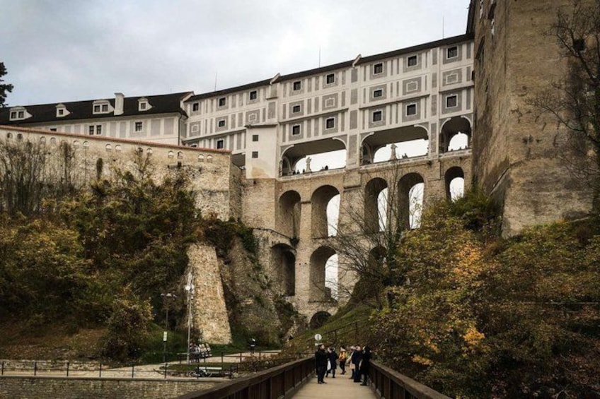 A historic building with multiple arches and a bridge leading to it. 2