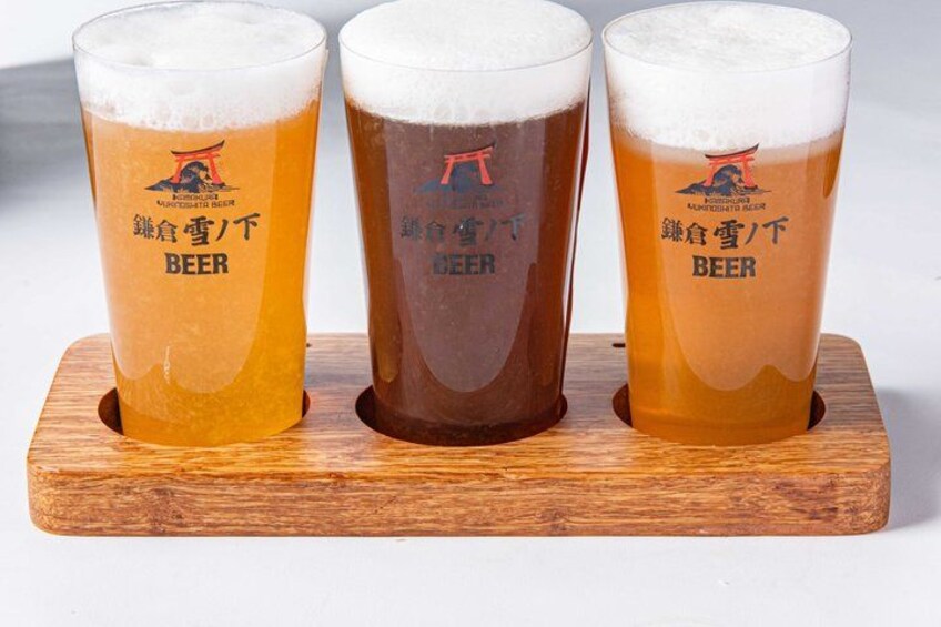 Three glasses of beer on a wooden coaster. 5