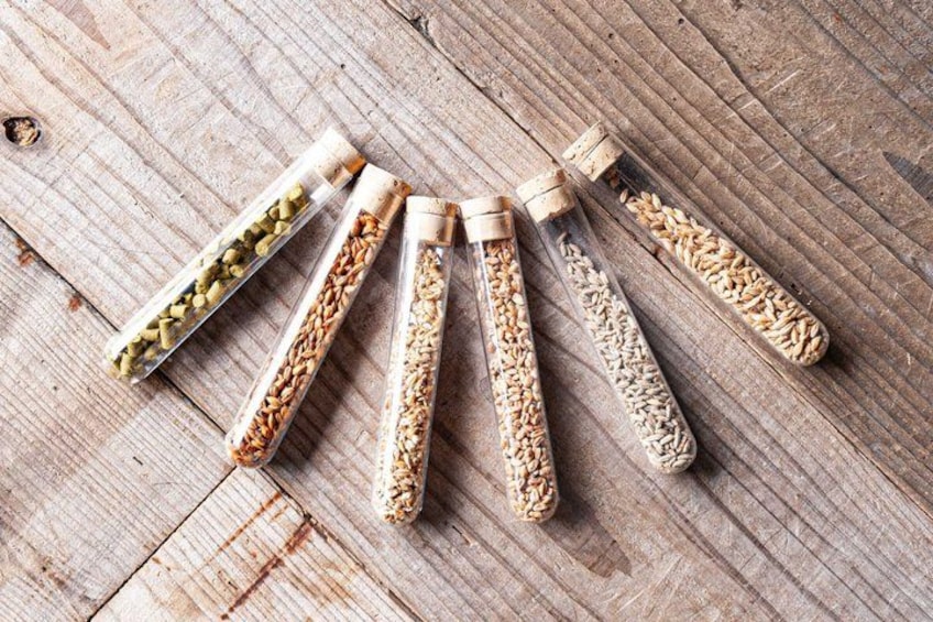 Five glass containers with different grains on a wooden surface. 4