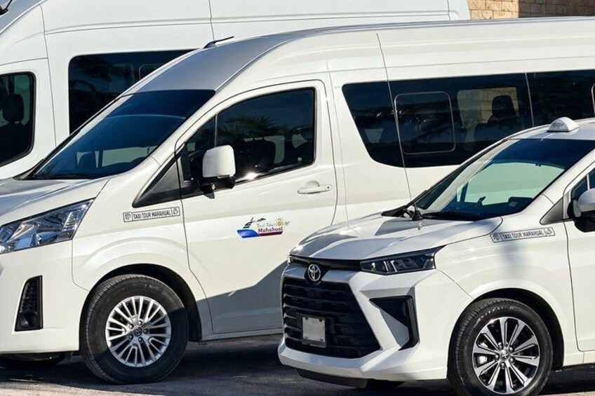Two white Toyota vans parked side by side. 2
