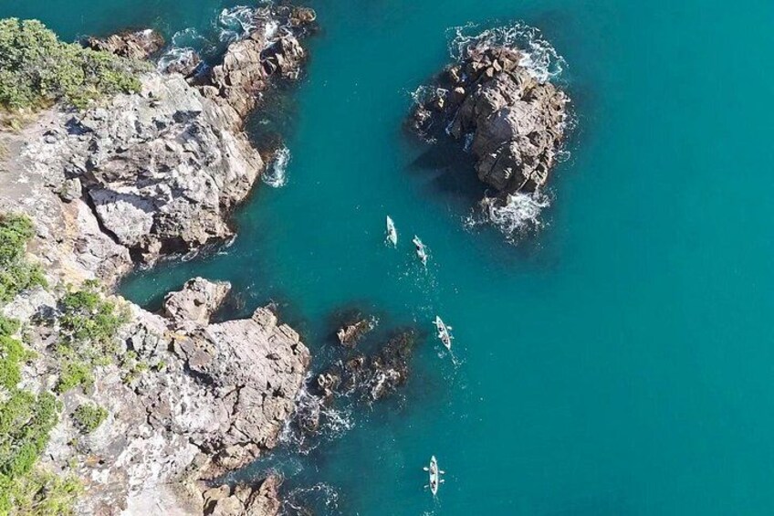 A coastal landscape with rocky outcrops and clear turquoise water. 5