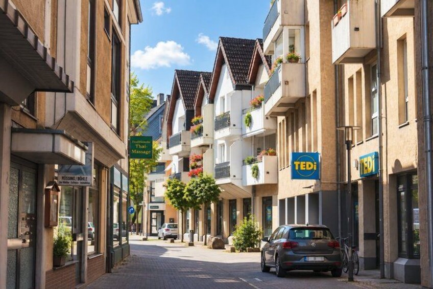 A street with buildings, a parked car, and a sign for a Thai massage. 5