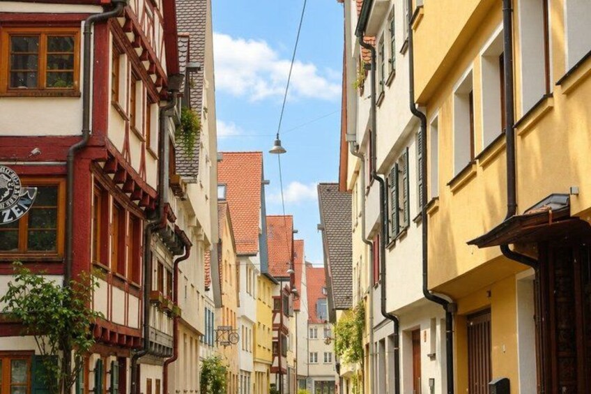 A narrow street lined with colorful half-timbered buildings. 5