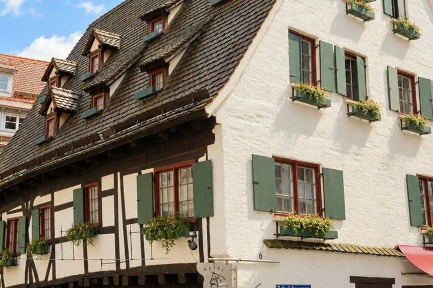 A traditional half-timbered house with green shutters and flower boxes. 2