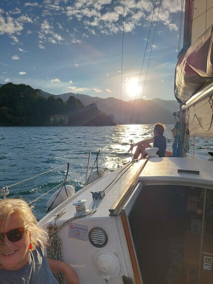 A boat on water with mountains in the background and the sun setting. 3