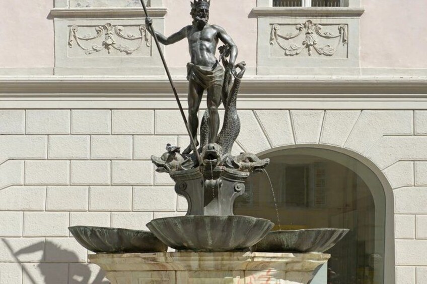 A bronze statue of a man holding a spear on a fountain with multiple basins. 4