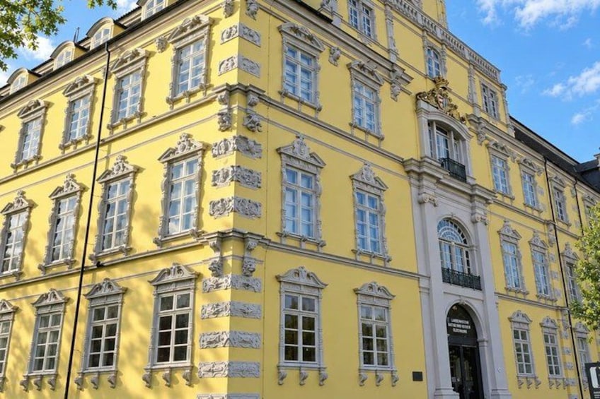 A yellow building with ornate architectural details, including multiple windows and decorative moldings. 3