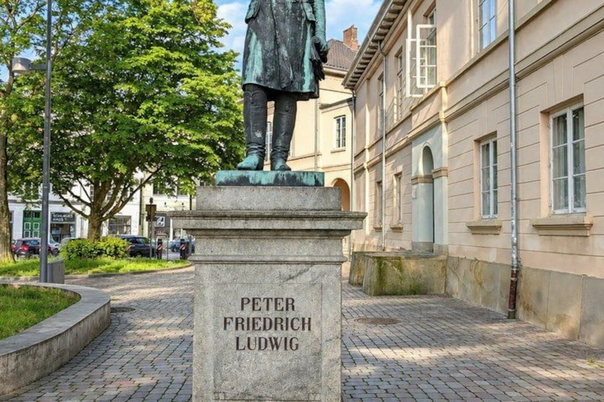 A statue of Peter Friedrich Ludwig on a pedestal in a cobblestone courtyard. 5