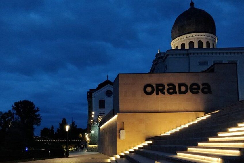 A building with a dome and the word 'ORADEA' on its facade. 2