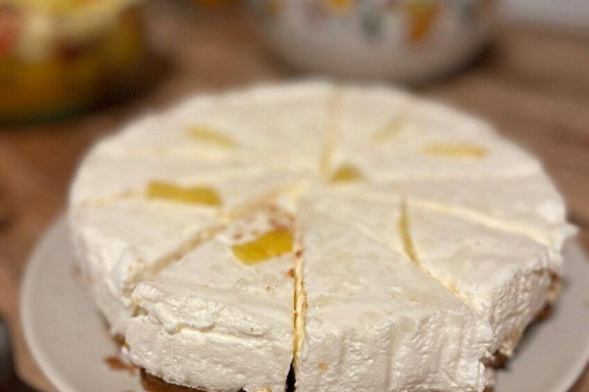 A round white cheese with yellow fruit pieces on top, sliced into wedges. 5