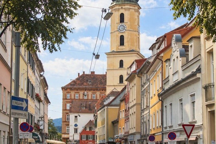 A street with historic buildings, a clock tower, and traffic signs. 5