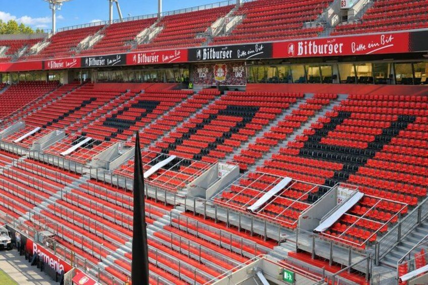 A stadium with red seats and a black spire. 3