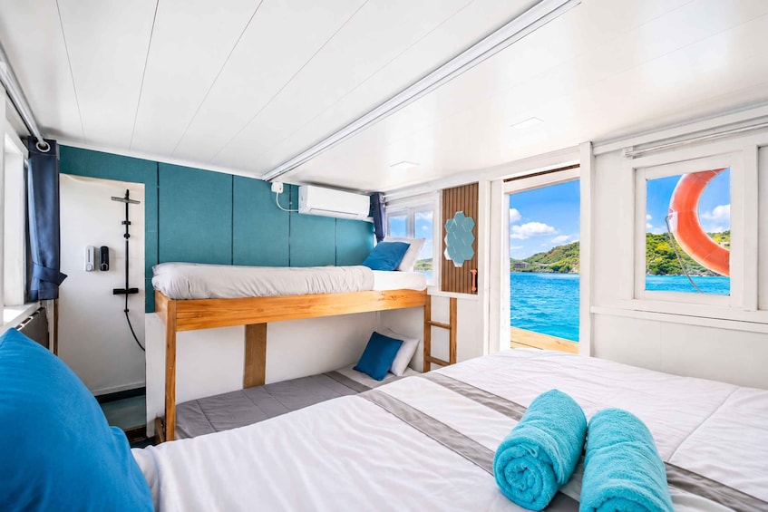Een blokhut met een stapelbed, een bureau en een raam met uitzicht op zee. 4