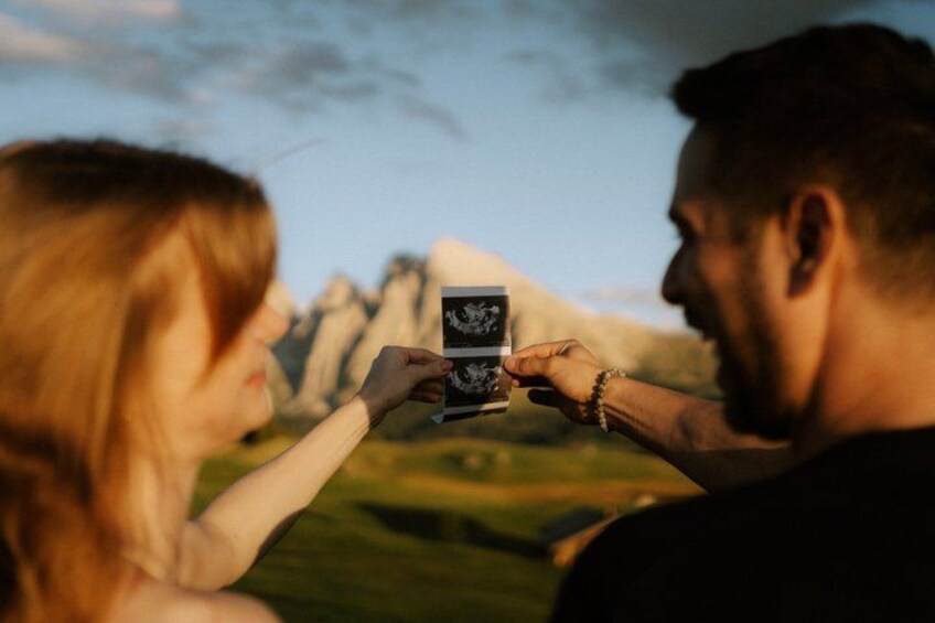 Two people holding a photograph. 3