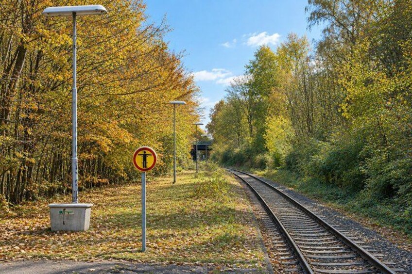 A railway track with a no-entry sign, surrounded by autumn foliage and a clear sky. 3