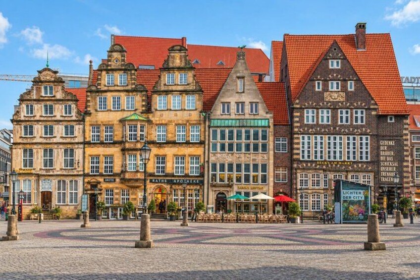 Historic buildings with red-tiled roofs and a cobblestone square. 3