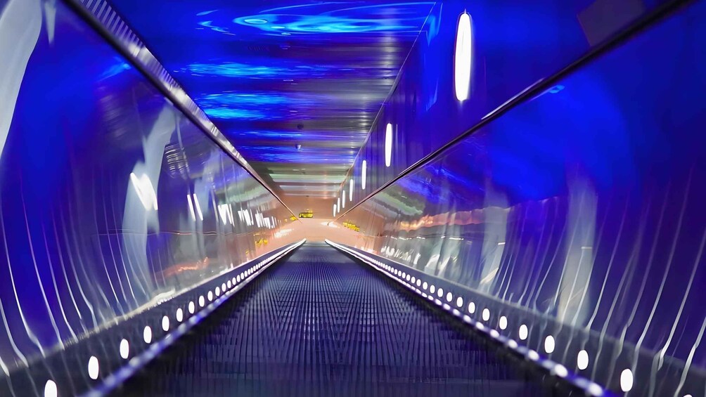 A tunnel with blue lighting and reflective surfaces. 3