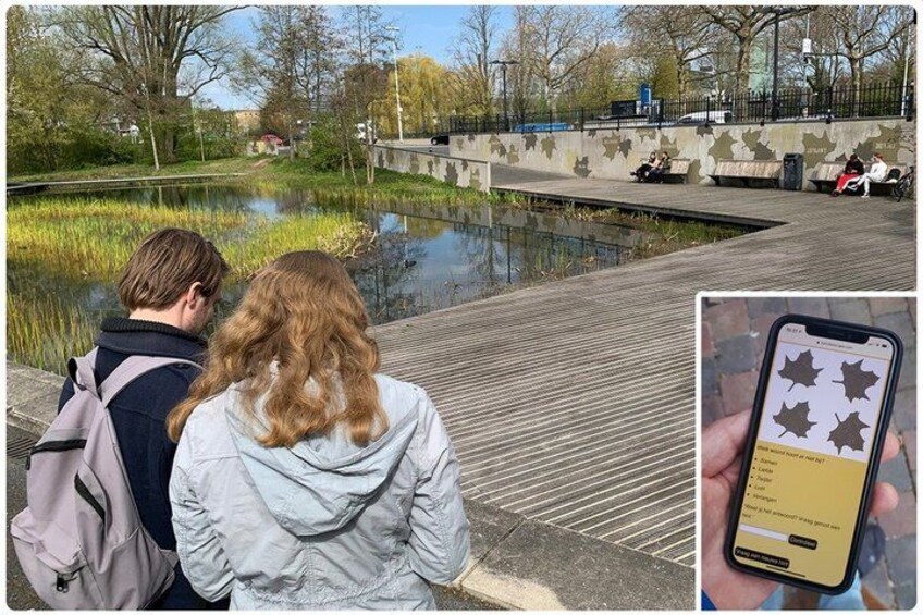 A couple sitting by a pond in a park with a smartphone displaying a map. 3