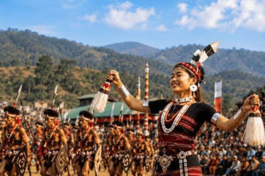 A person in traditional attire with a mountainous landscape in the background. 1