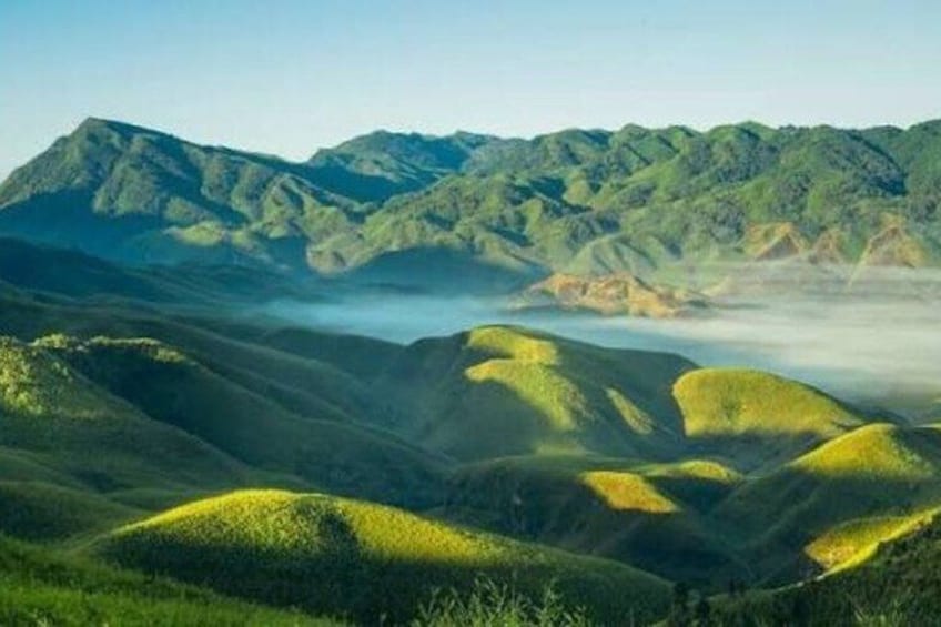 Rolling green hills, a valley, and distant mountains. 3