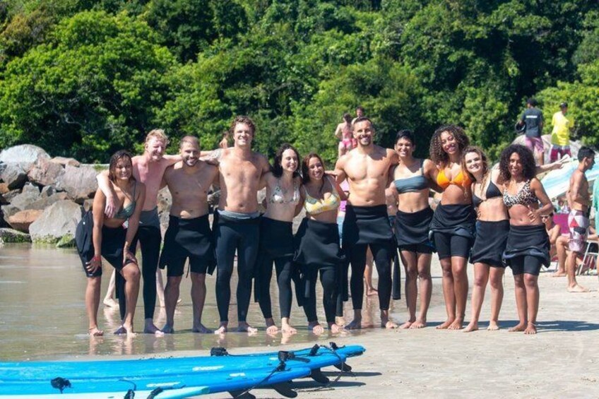 A group of people standing on a beach with surfboards. 5