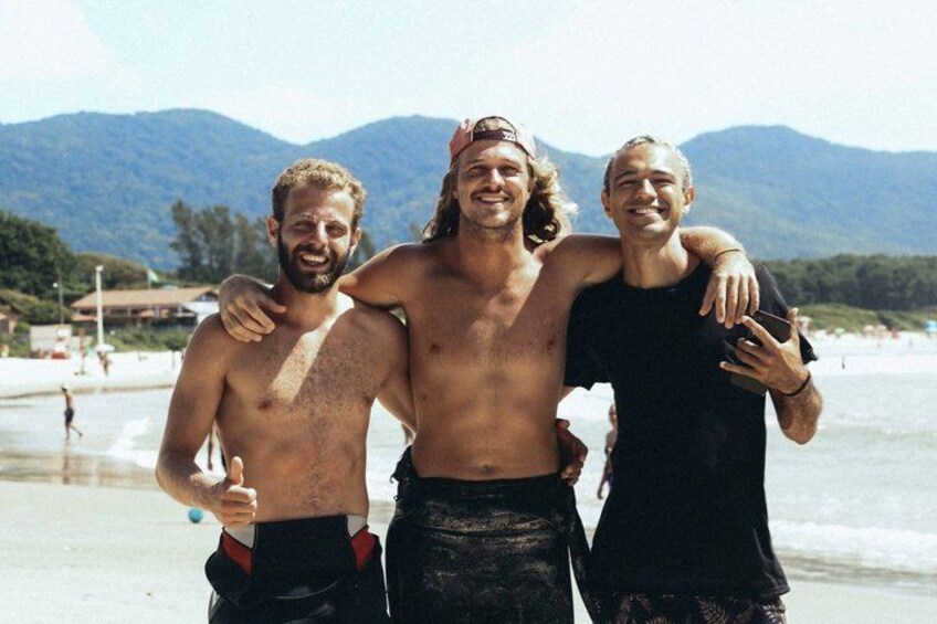 Three people on a beach with mountains in the background. 2