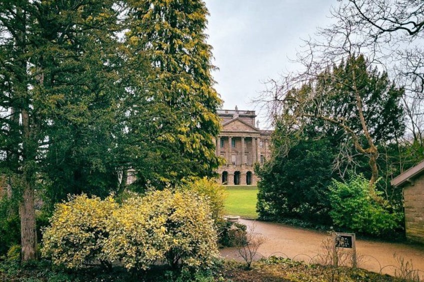 A large building with columns, surrounded by trees and a well-maintained lawn. 3