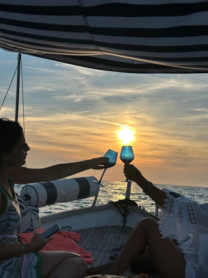 Tramonto sull'oceano con due persone che brindano con i bicchieri. 3