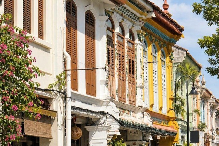 A row of colorful colonial-style buildings with ornate facades and wooden shutters. 4