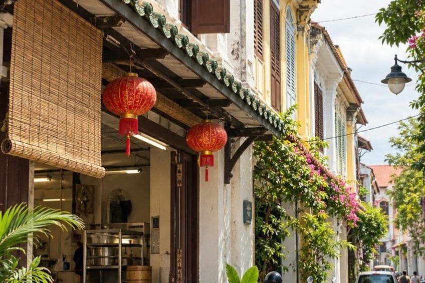 A traditional street with buildings, red lanterns, and greenery. 2