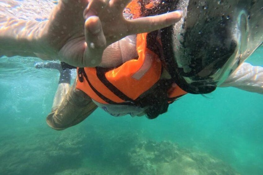 A person underwater wearing an orange life jacket. 2