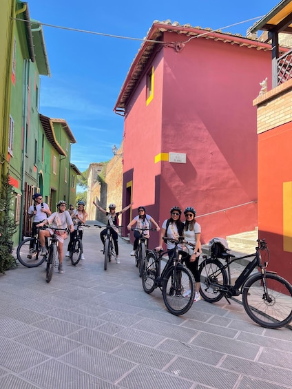 A group of cyclists on a cobblestone street with colorful buildings. 1