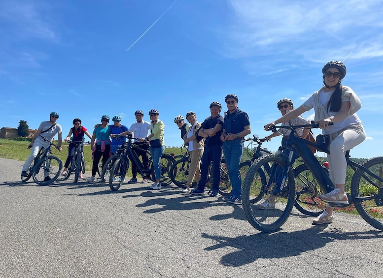 A group of people on bicycles on a paved path with a clear sky. 3