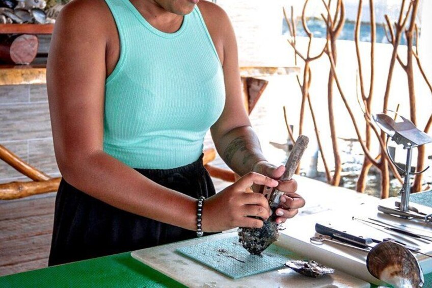 A person working with a tool on a green surface, surrounded by wooden branches and a metal object. 5