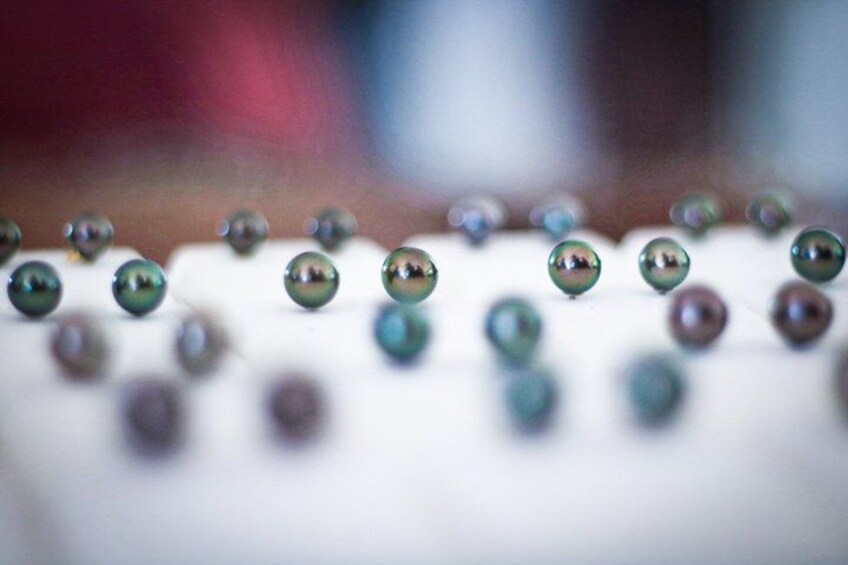 A close-up of spherical objects with a reflective surface, possibly glass or polished metal, arranged in a pattern on a flat surface. 4