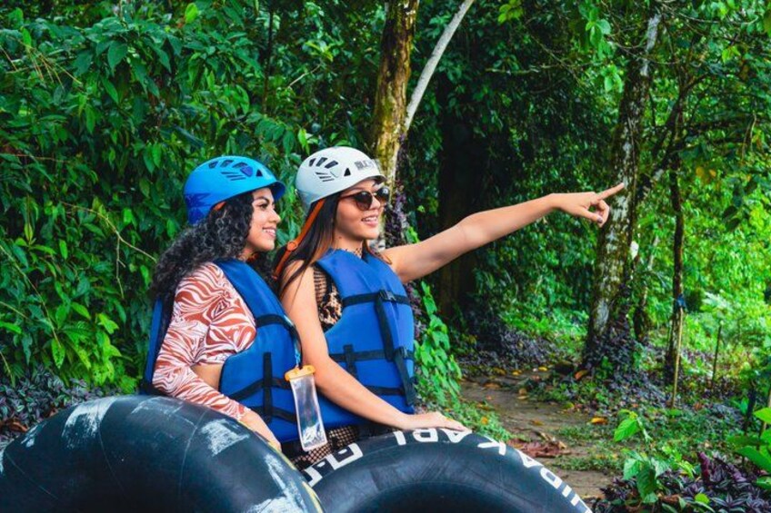 Two people rafting in a forested area. 5