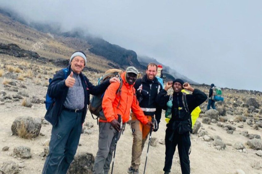 A group of hikers on a rocky terrain with a mountain in the background. 2