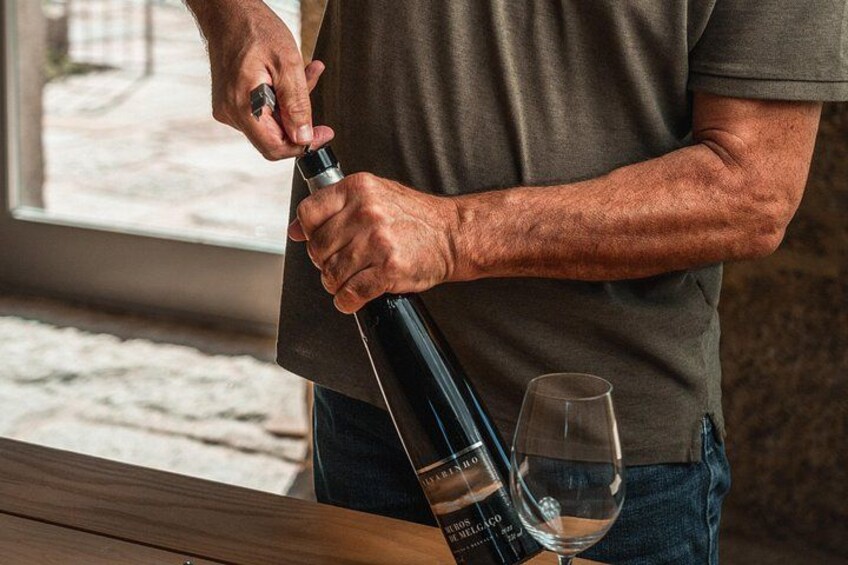 A person pouring wine into a glass. 5