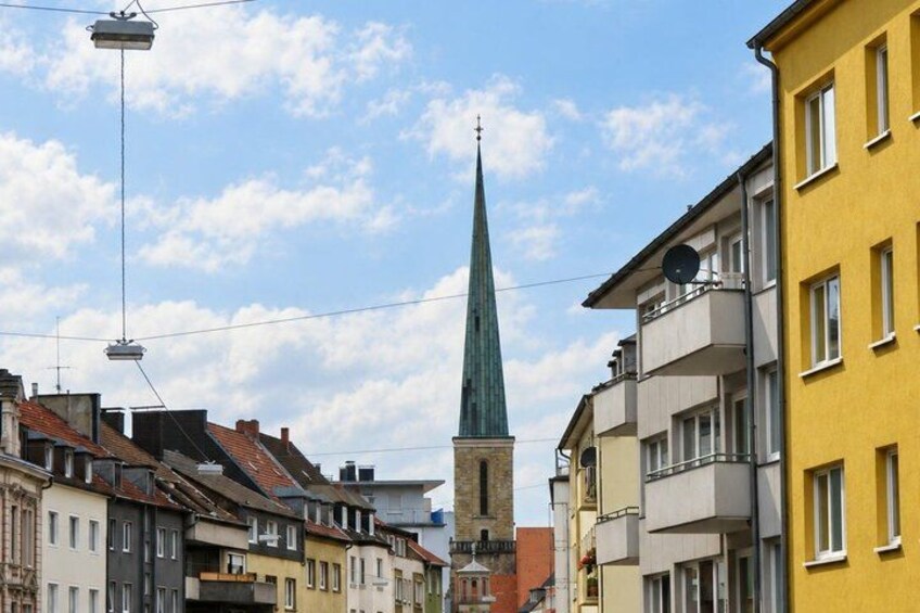 A church spire, residential buildings, and a clear sky. 5