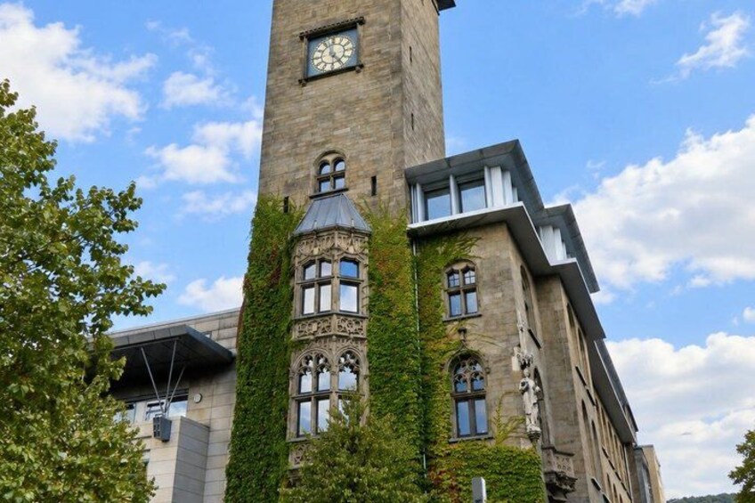 A tall tower with a clock, surrounded by trees and a clear sky. 2