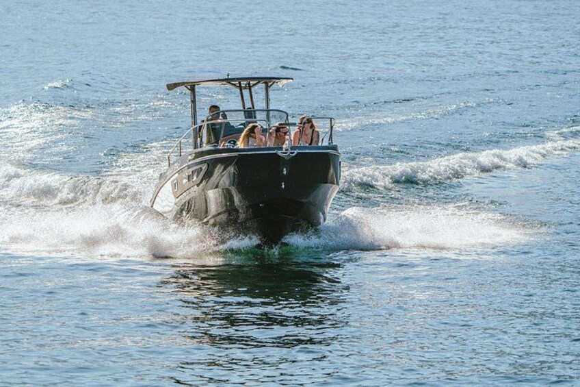 A boat with passengers moving through water. 2