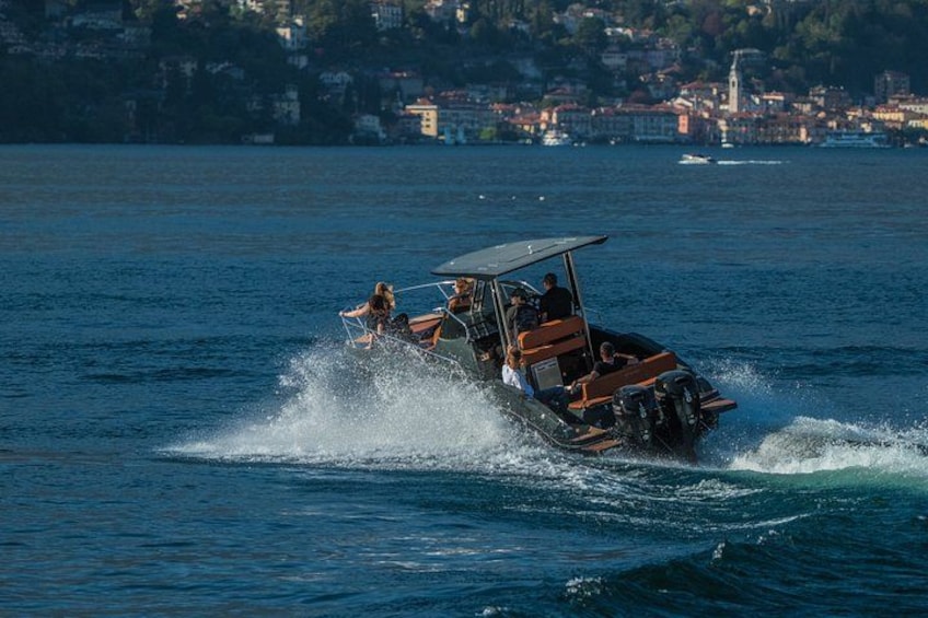 A speedboat with passengers, creating a wake in the water, with a coastal town in the background. 3