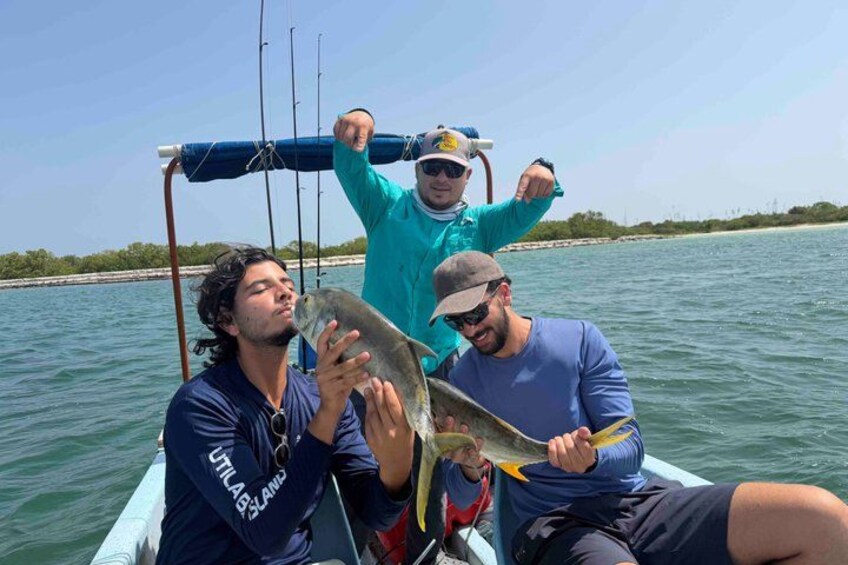Three people on a boat holding a fish. 3