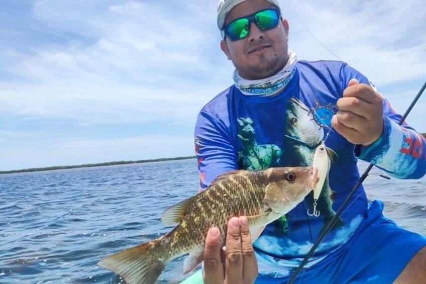 A person holding a fish on a boat. 5
