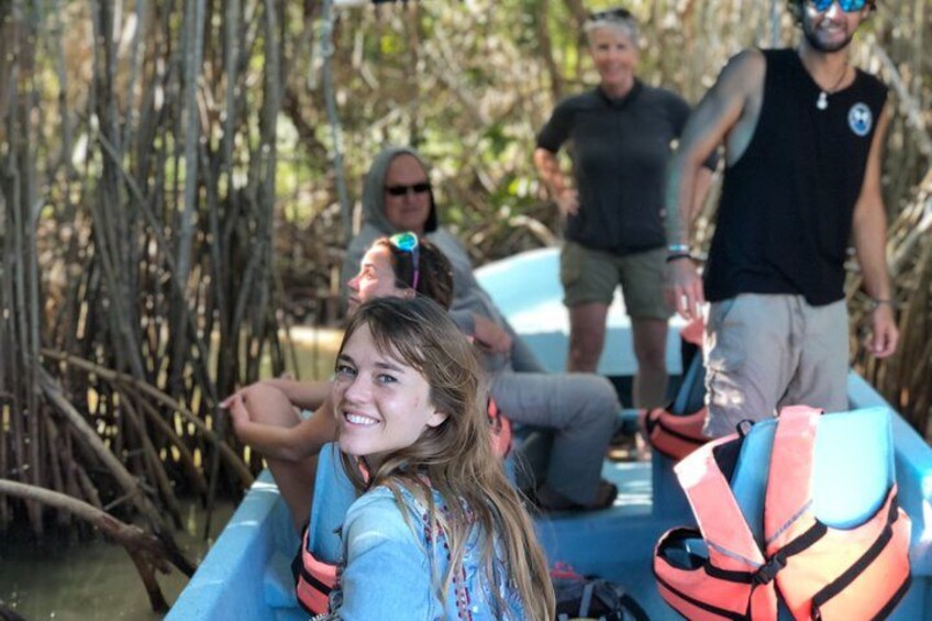 People in a blue boat on a river surrounded by trees. 2