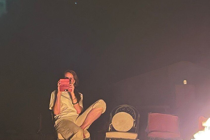 A person sitting on a chair with a red object in their hands. 1
